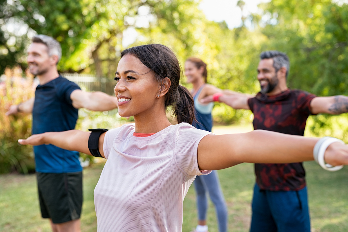 group of people in the park doing yoga